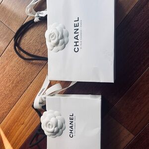 CHANEL two Elegant White paper bags with ribbon and camelion and one Black bag